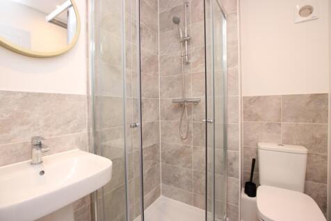 Bright, modern bathroom featuring a glass-enclo...