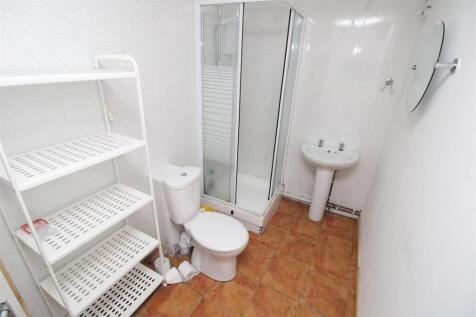 Bright bathroom with ample shelving and shower...