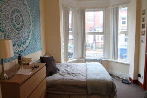 A spacious and well-lit master bedroom featurin...