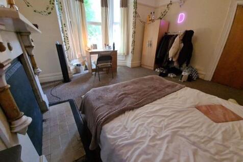 A spacious and well-lit master bedroom featurin...