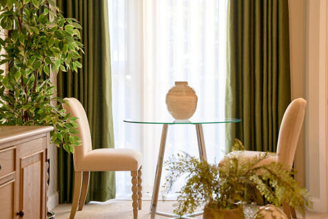 a chair and a plant in a room with a window