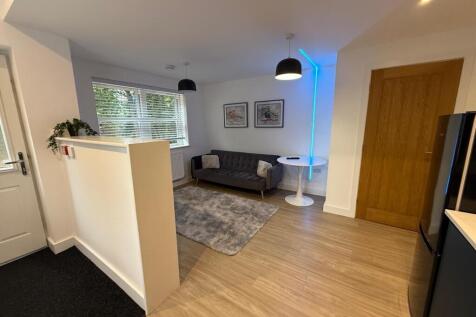 Bright, modern living area with a grey upholste...