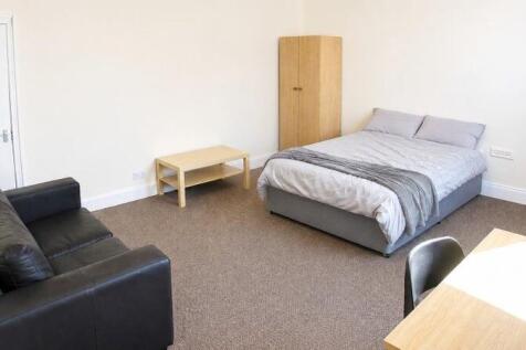 Spacious master bedroom with double bed and sof...