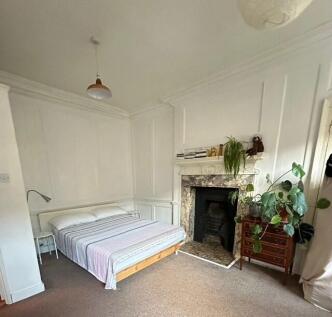 Bright master bedroom with feature fireplace...