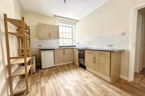 Bright kitchen with fitted units and wood floor...