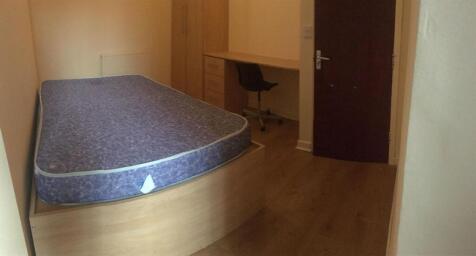 Simple, tidy bedroom with wooden flooring, fitt...