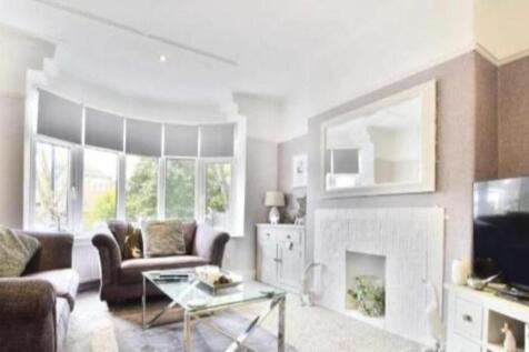 Bright lounge with a bay window and fireplace...