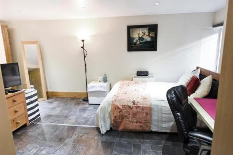 Spacious modern bedroom with desk and double be...