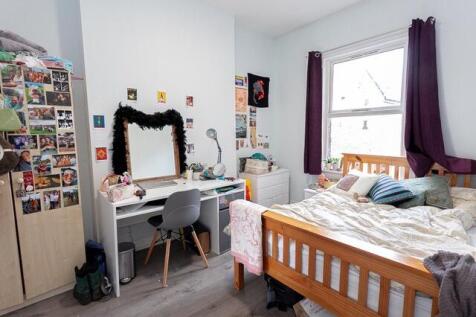 Bright bedroom with large desk and double bed...