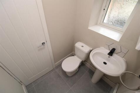 Bright and modern cloakroom with stylish tiling...