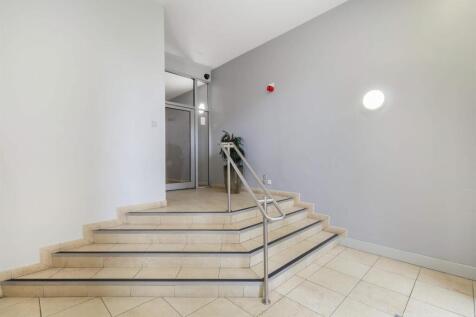 Bright modern foyer with wide tiled staircase...