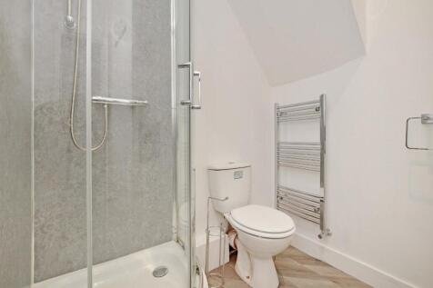 Bright, modern bathroom with a glass shower enc...
