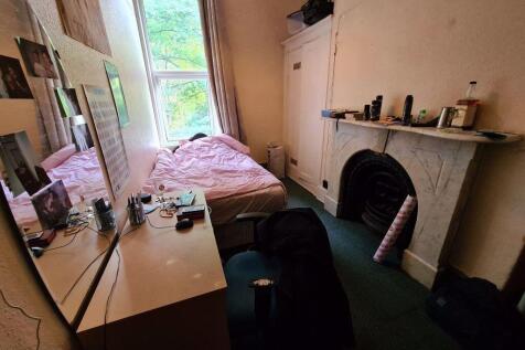 Cozy bedroom featuring a large window providing...