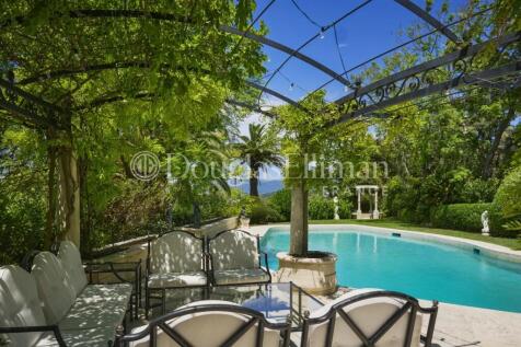 A serene outdoor scene features a lush green pergo