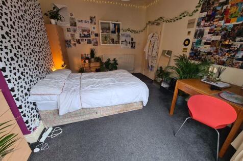 A well-lit, inviting master bedroom featuring a...