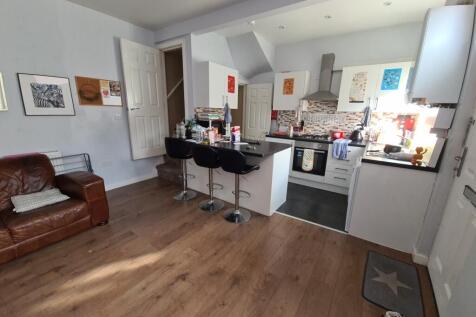A modern, open-plan kitchen featuring a wooden ...