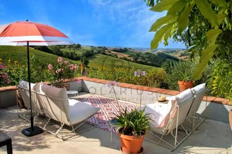 A serene terrace with two cushioned chairs and a r