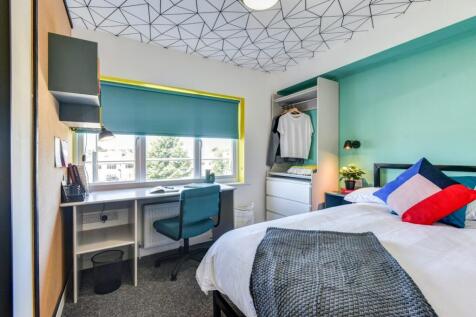 Bright and stylish bedroom featuring a large wi...