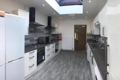 Bright, modern galley kitchen with sleek white ...