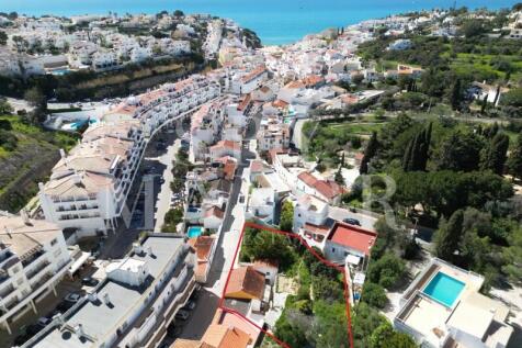 Aerial view of land plot for sale in Carvoeiro center, Algarve. Real estate investment opportunity with approved project for luxury apartments near the beach.