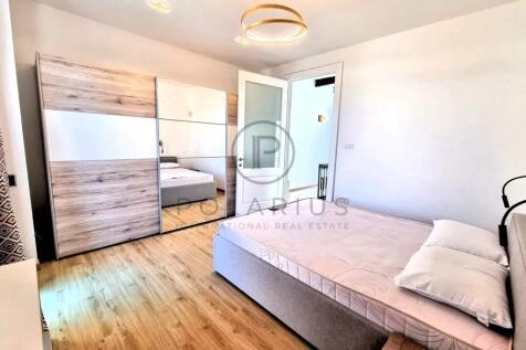 A modern bedroom with a wooden floor, featuring a 