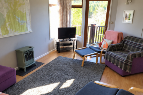Bright lodge lounge with doors opening onto the de