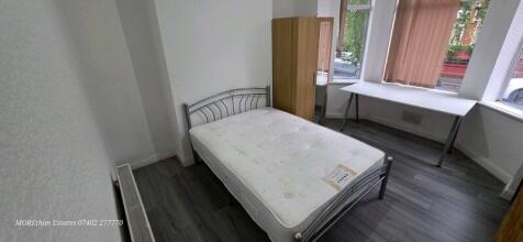Bright ground-floor double bedroom with a metal...