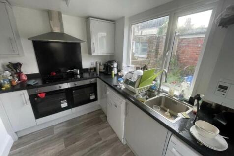 Bright galley kitchen with large window overloo...