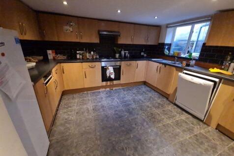 A spacious, modern kitchen featuring ample wood...