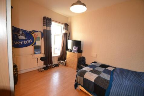 A bright, simply furnished double bedroom with ...