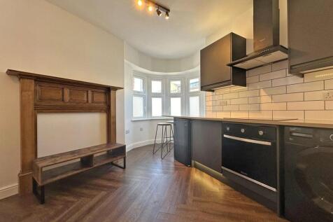 Modern kitchen with bay window and parquet floo...