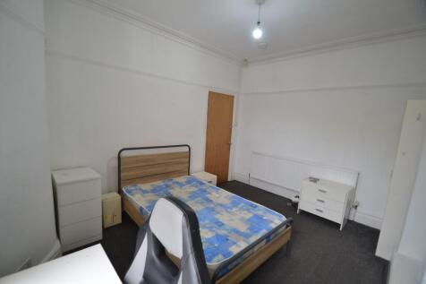 A modest single bedroom featuring a bed with a ...