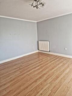 Bright, neutral living room with pale grey wall...