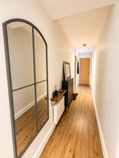 Bright modern hallway with stylish arched mirro...