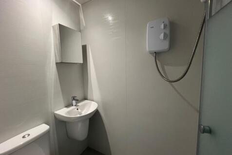 Bright compact bathroom with modern white fitti...
