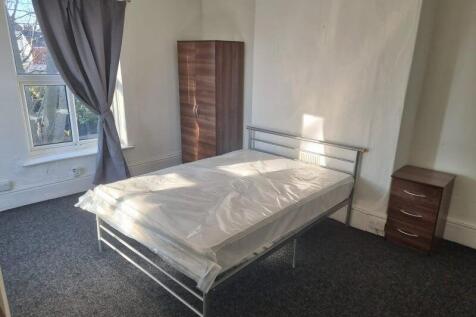 Bright, well-lit bedroom with a metal double be...