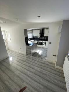 Modern open-plan kitchen with sleek wood floori...