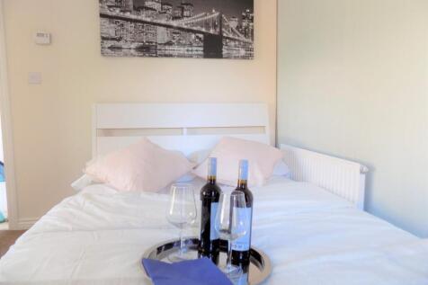 Bright, tidy double bedroom with a white headbo...