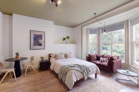 Bright, stylish bedroom with bay window seating...