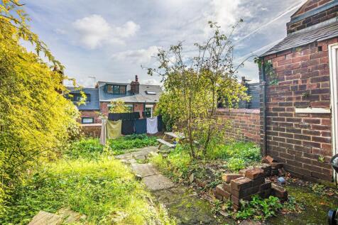 Sunny private rear garden with paved path, matu...
