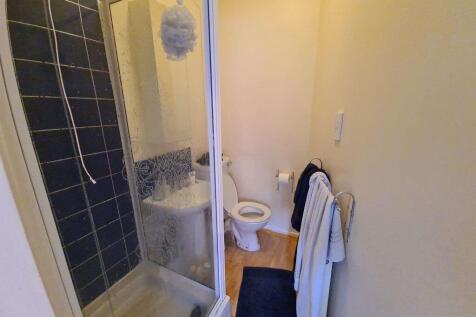 A compact bathroom featuring a modern shower cu...