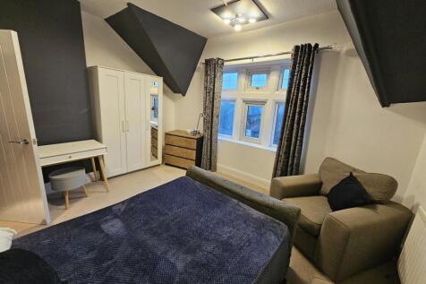 A spacious master bedroom featuring a comfortab...