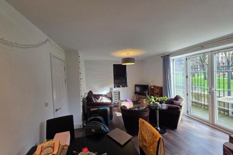 Bright open living room with floor-to-ceiling p...