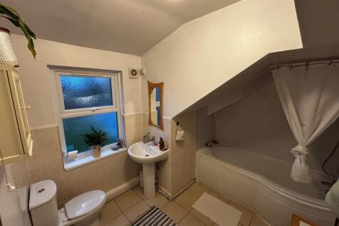Bright, well-kept bathroom with a shower-over-b...