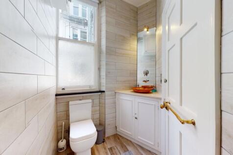 Bright and neat bathroom featuring modern fitti...