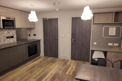 Modern open-plan kitchen area with sleek grey c...