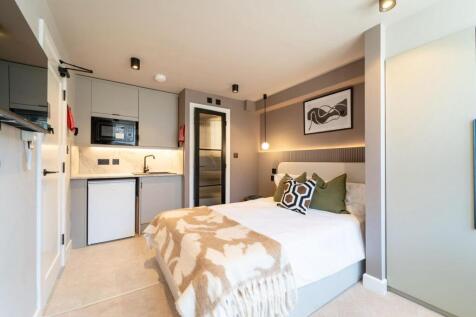 Modern studio with comfy bed and sleek kitchene...