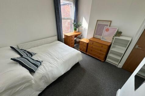 A well-maintained double bedroom with a comfort...