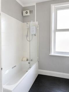 Pristine bathroom with a full tub and window...