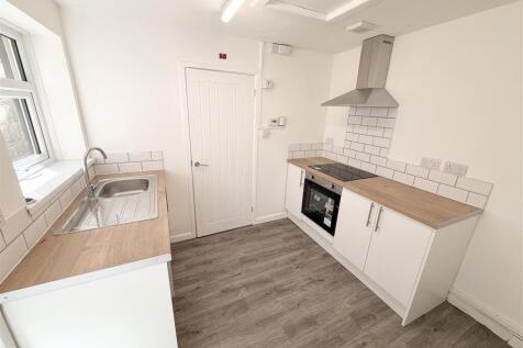 Modern bright kitchen with sleek white cabinets...